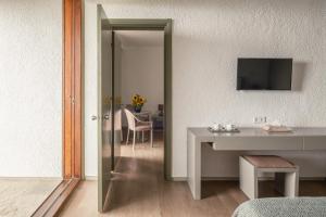 a living room with a table and a mirror at Amalia Hotel Delphi in Delfoi
