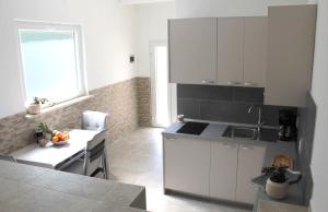 a kitchen with white cabinets and a table and a window at Horizont view apartment in Pula