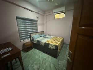 a small bedroom with a bed and a table at Janani Silver Apartment Chathannoor, Kottiyam in Kottiyam