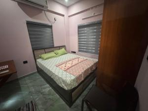 a small bed in a room with a window at Janani Silver Apartment Chathannoor, Kottiyam in Kottiyam +1 photo