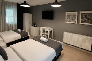 a bedroom with two beds and a desk and a television at Utarit Hotel in Istanbul