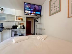 a bedroom with a white bed with a tv on the wall at !GoldPath! Passau - Central - Innpromenade - Uniwiese in Passau
