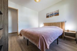 a bedroom with a large bed and a table at Renovated apartment with terrace for 14 people in Saint-Jean-de-Maurienne