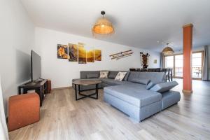 a living room with a couch and a tv at Renovated apartment with terrace for 14 people in Saint-Jean-de-Maurienne