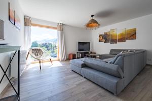 a living room with a couch and a tv at Renovated apartment with terrace for 14 people in Saint-Jean-de-Maurienne +36 photos