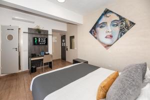 a bedroom with a bed with a painting on the wall at Rise Urban Art Hotel in Larnaca
