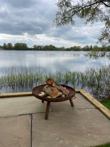 a table with bread on it next to a lake at 1 Willowmere lakeside Hideaway in Baston +1 photo
