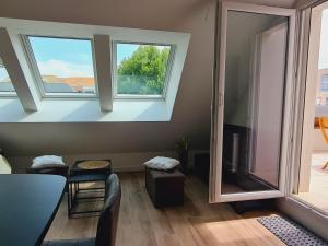 a living room with two windows and a table and chairs at Studio Neuf 23m² Proche Plage et Centre Tout Inclus - FR-1-364-183 in Saint-Brevin-les-Pins