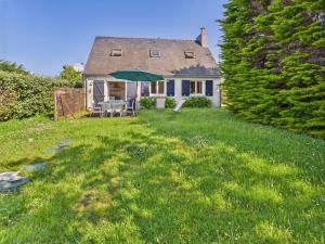 a house with a green umbrella in the yard at Maison pour 6 avec jardin à 1 km de la plage in Penmarcʼh