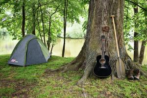 una tenda e una chitarra accanto a un albero di Apartmány & Kemp Sázavský ostrov a Sázava