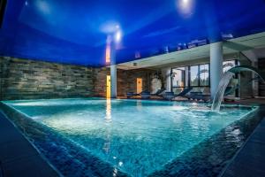 a swimming pool in a building with a blue ceiling at Woodland Apartment in Silver Mountain Resort in Poiana Brasov