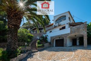 a palm tree in front of a building at Casa Serena in Vall-Llobrega