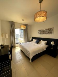 ドバイにあるBeachside 2BR Marina Viewsのベッドルーム1室(ベッド1台、デスク、2つの照明付)