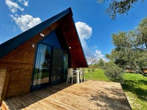 a house with a wooden deck with two chairs on it at Nefesurla Bungalov 5 in Urla