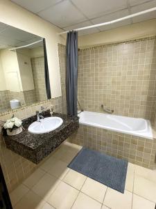 ドバイにあるBeachside 2BR Marina Viewsの洗面台、浴槽、鏡のあるバスルーム