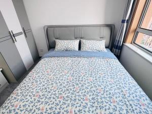 a bedroom with a bed with a blue and pink comforter at Little Room in Ruakura Junction