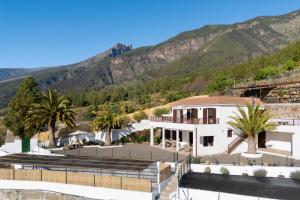 une maison avec des palmiers et des montagnes en arrière-plan dans l'établissement Finca Villa La Palmera, amazing sea views, à Arafo