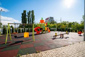 a park with a playground with swings and a slide at Real Resort in Ploieşti