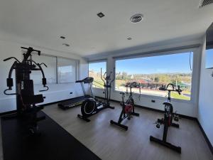 a gym with three elliptical machines and a large window at Pie de Piedra Hotel Boutique in Sierra de la Ventana