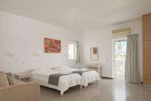 a bedroom with two beds and a couch at Reina Apartments in Georgioupolis
