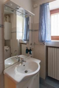 a bathroom with a white sink and a mirror at Appartamento Il Pozzo in San Felice del Benaco +25 photos