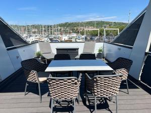 a table and chairs on a balcony with a marina at Floating House - SEA SUITE in Portorož