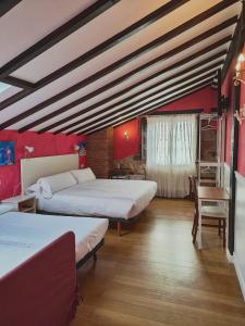 a room with two beds and a table and chairs at Posada el Remanso de Trivieco in La Cavada