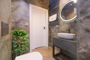 un baño con lavabo y espejo en Laguna Beskidów Resort - Apartament Leśny, en Zarzecze