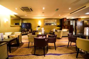a hotel lobby with tables and chairs and a television at Crowne Plaza London Ealing by IHG in London