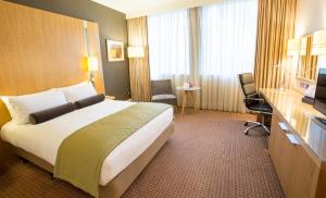 a hotel room with a large bed and a television at Crowne Plaza London Ealing by IHG in London