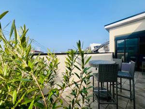 a patio with two chairs and a table on a balcony at Cielito Hayama 最大10名 海まで10分 テラスBBQ 葉山の空と海と富士山に出会うヴィラ in Hayama