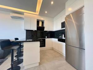 a kitchen with white cabinets and a stainless steel refrigerator at Boutique 16 - Alanya Experience in Alanya