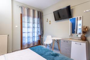 Un dormitorio con una cama y un televisor en la pared. en House Panorama Sea View, en Neos Marmaras