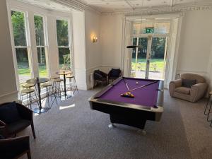 a room with a purple pool table in it at The Beeches - Entire Mansion in Bristol