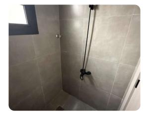 eine Dusche mit Glastür im Badezimmer in der Unterkunft A new studio near the airport in Quai