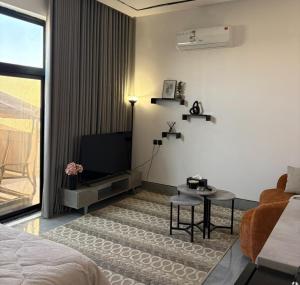 Zimmer mit einem Bett, einem TV und einem Sofa in der Unterkunft A new studio near the airport in Quai