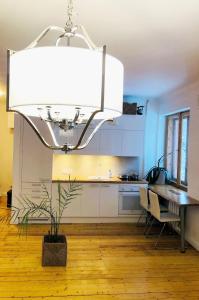 a kitchen with a dining table and a chandelier at Self check-in spacious apartment in a quiet area in Rīga