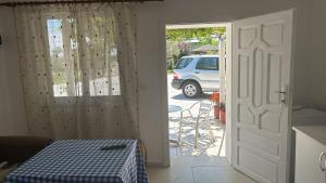 a kitchen with a door open to a patio with a van at Dhoma Pushimi Tale Beach in Lezhë