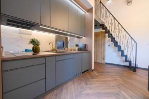 una cocina con armarios grises y una escalera en Laguna Beskidów Resort - Apartament Leśny, en Zarzecze 10 fotos más