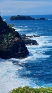a view of the ocean with rocks in the water at Villa Jamrosat in Petite Île