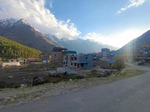 a town on a hill with mountains in the background at RR Homestay Chitkul in Chitkul