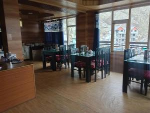 a dining room with tables and chairs and windows at RR Homestay Chitkul in Chitkul +32 photos