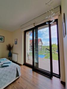 Schlafzimmer mit einem Bett und einer großen Glasschiebetür in der Unterkunft Lisi Jar in Jastrzębia Góra