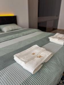 two white towels sitting on top of two beds at Casa Vista Premium 2BR Apartment with Free Parking in Sofia +22 photos