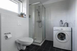 a bathroom with a toilet and a washing machine at Waterpark Oan 'e Poel bij Sneekermeer in Terherne +81 photos