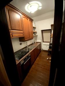 Sauze d'OulxにあるSauze D'Oulx Penthouse Apartmentの木製のキャビネットとシンクを備えたキッチン