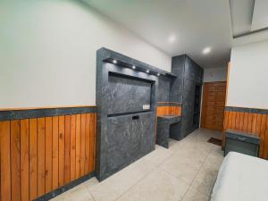 a bedroom with a large stone fireplace in the wall at Tara Van in Dharamshala