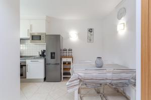 a white kitchen with a table and a refrigerator at Glenridge Resort By Albufeira Rental in Albufeira