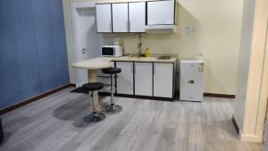 a kitchen with a counter and stools in a room at Open Hotel Buraiyda in Buraydah
