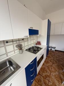 a kitchen with blue and white cabinets and a sink at Giardinetto Apartment in Lido di Jesolo